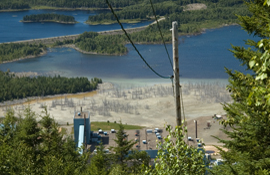 The Adex mine site, viewed from the Mount Pleasant summit, facing south. Mine buildings and tailings pond appear in the foreground, adjacent to the diversion dam and Hatch Brook headpond in the upper left.